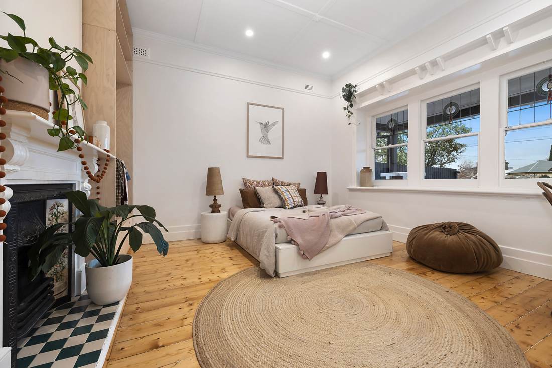 Front bedroom with restored floral-tile fireplace, checkerboard hearth and leadlight windows