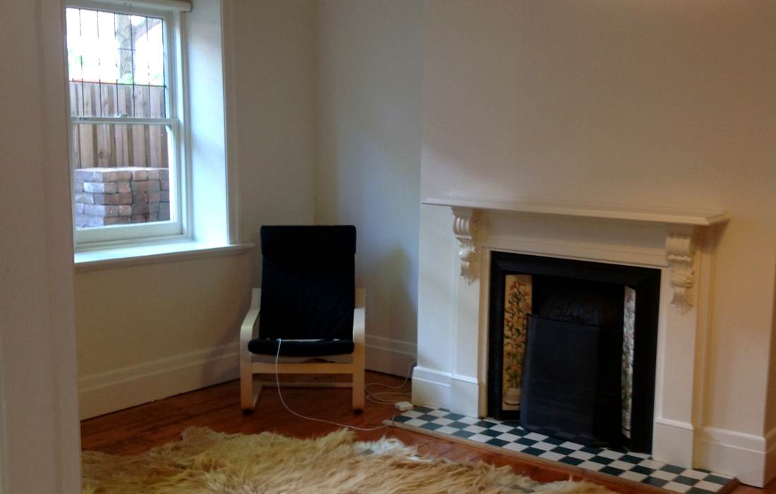 The lounge before — the original mantle and bare boards
