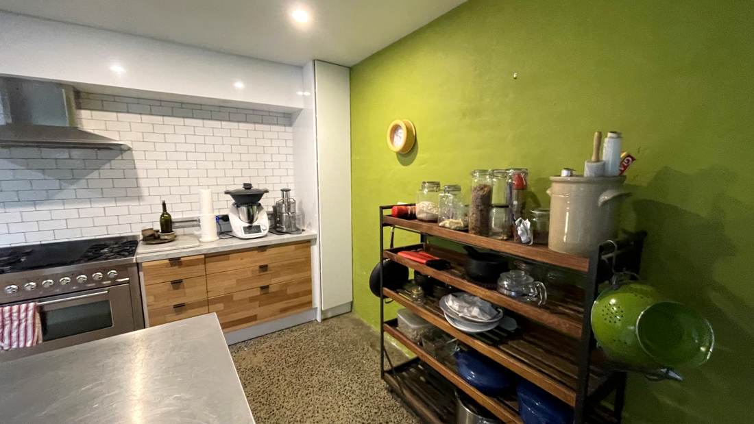 The kitchen before — green render walls and cluttered benches