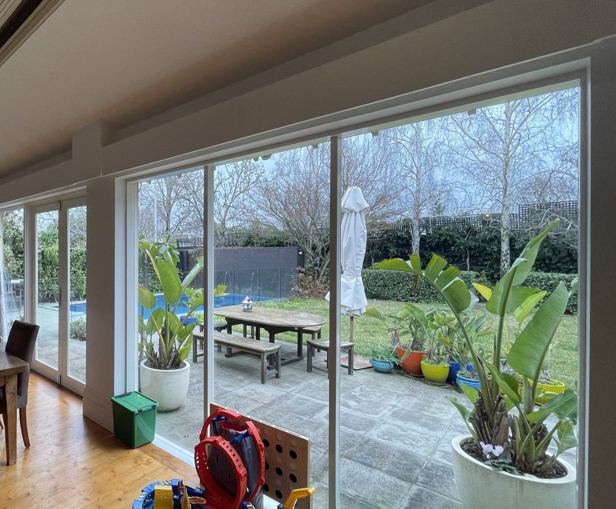 The rear living area before — timber bifold doors and fixed glazing to the garden