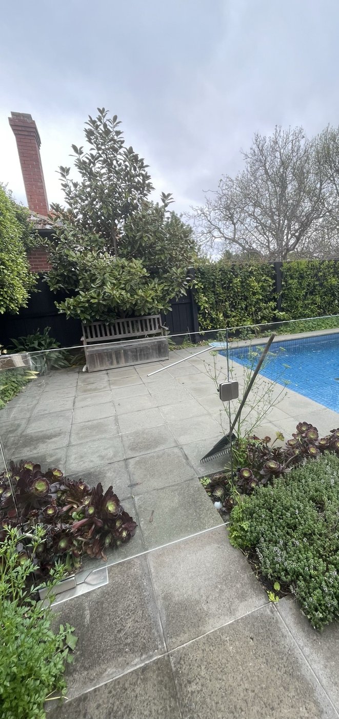 The garden and pool before the work — blue-tiled pool and worn paving